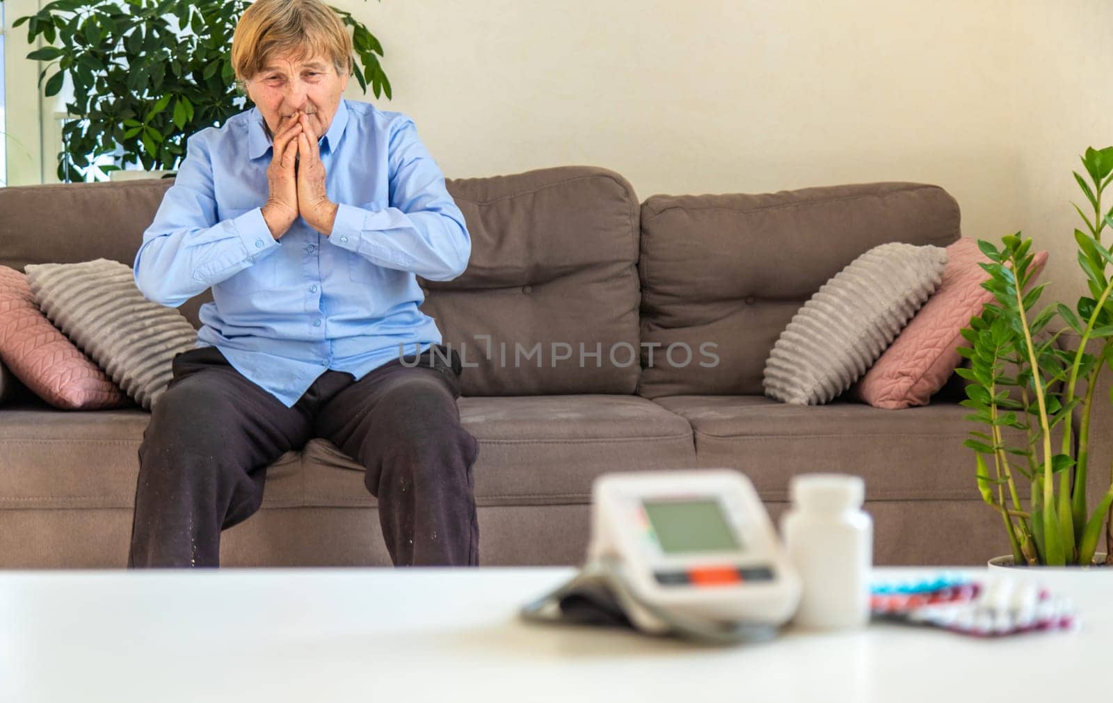 An old woman measures her blood pressure. Selective focus. people,