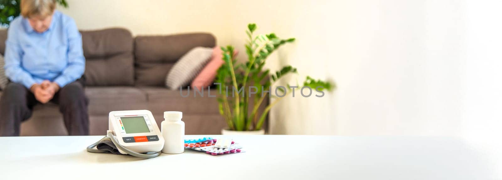 An old woman measures her blood pressure. Selective focus. people,