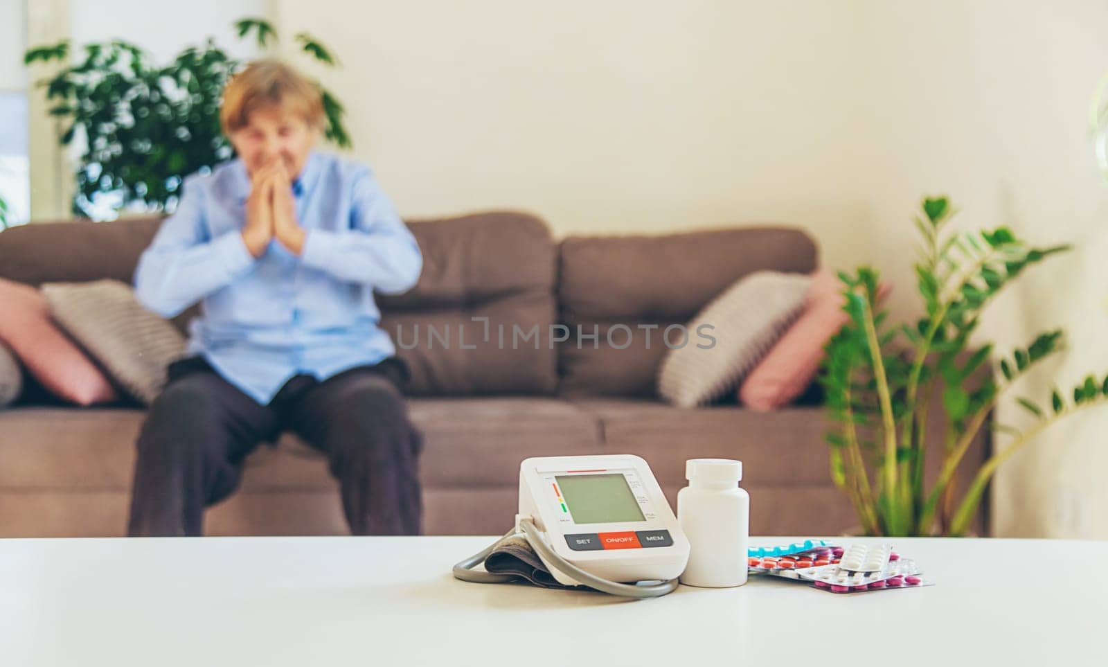 An old woman measures her blood pressure. Selective focus. people,