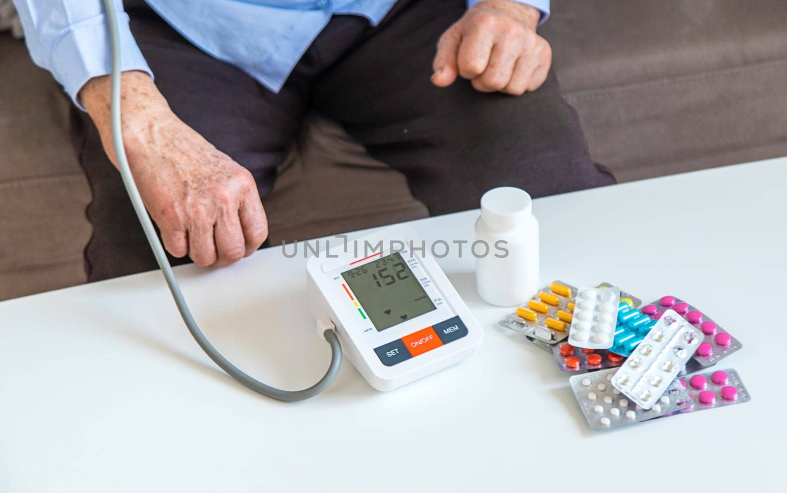 An old woman measures her blood pressure. Selective focus. people,
