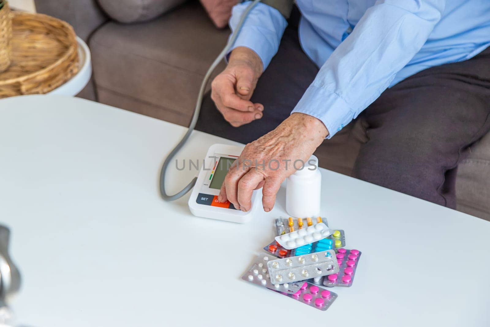 An old woman measures her blood pressure. Selective focus. people,