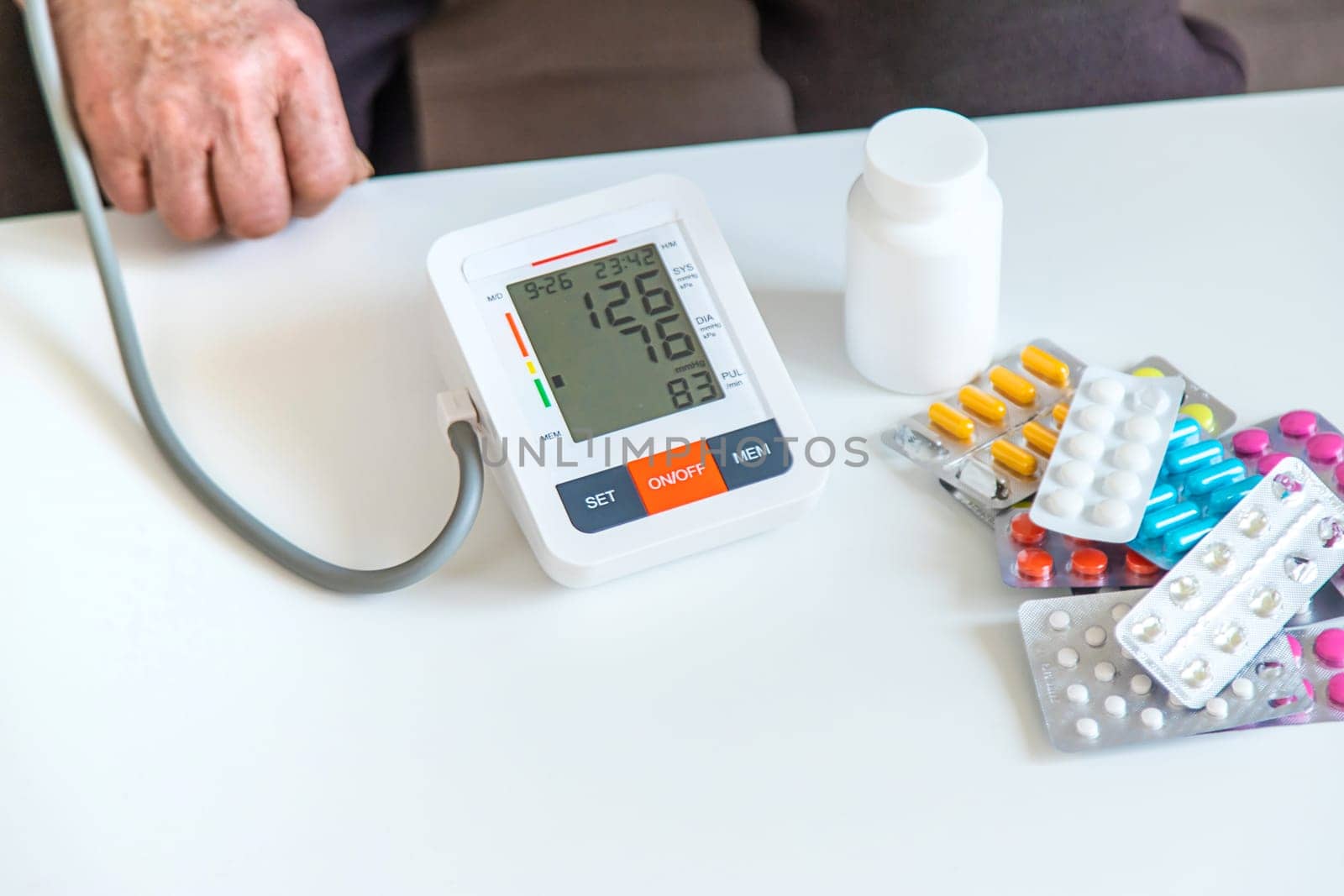 An old woman measures her blood pressure. Selective focus. people,