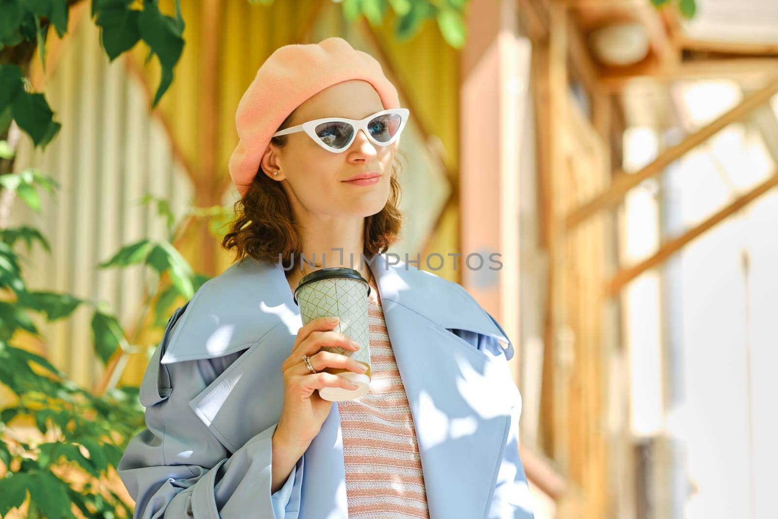 Satisfied stylish woman with cup of coffee outdoors on sunny day