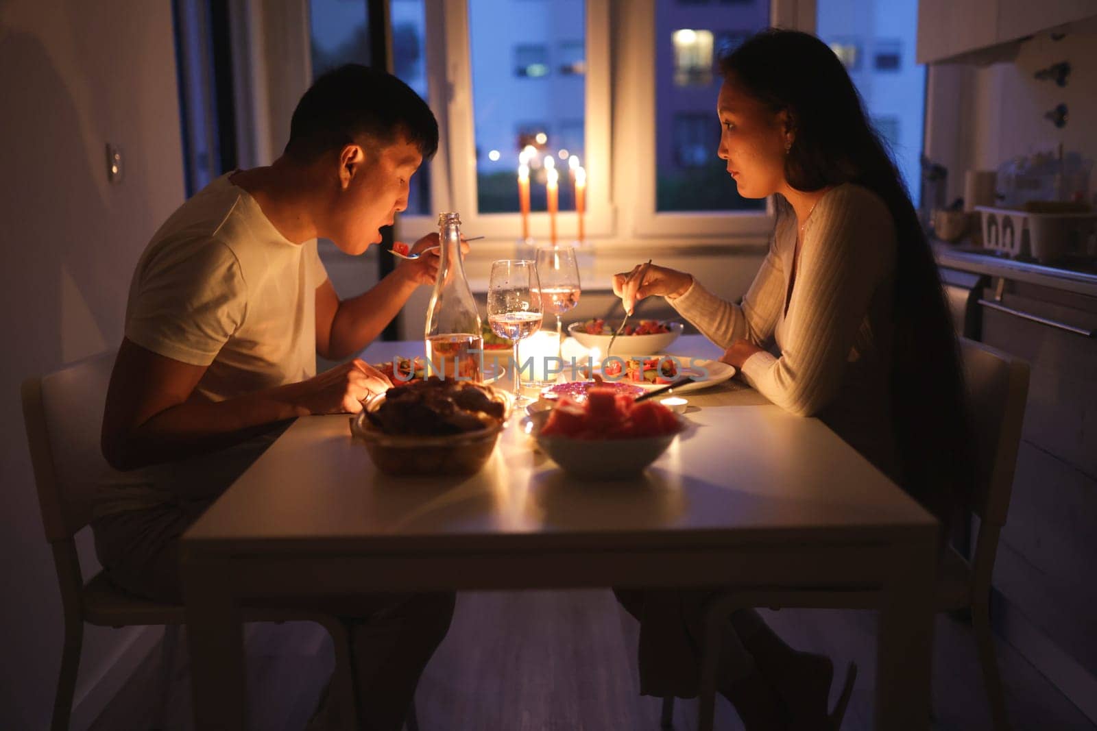 Young multi-ethnic couple having a romantic candlelit dinner in their apartment