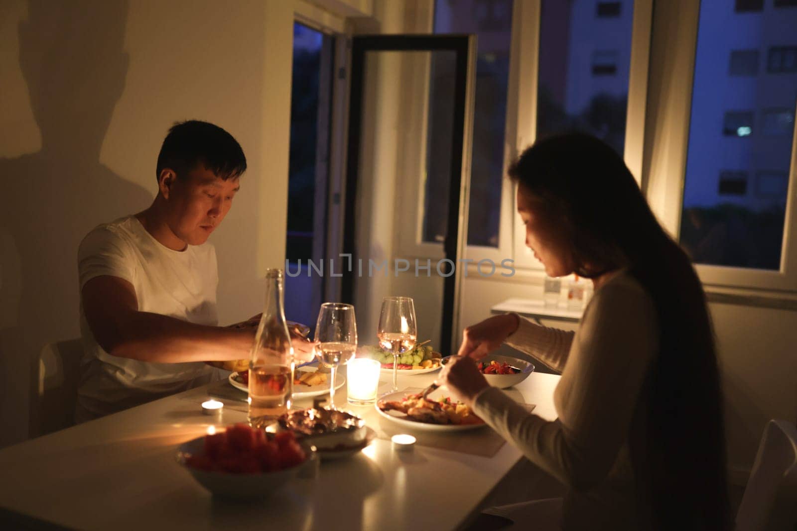 Young couple having a romantic candlelit dinner at their cozy home