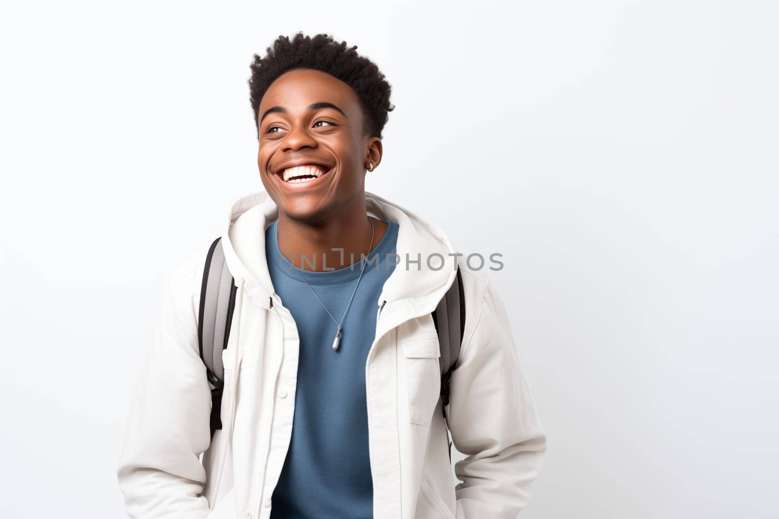 Portrait of happy modern young black American man smiling on white background, African male student with backpack standing, studio shot
