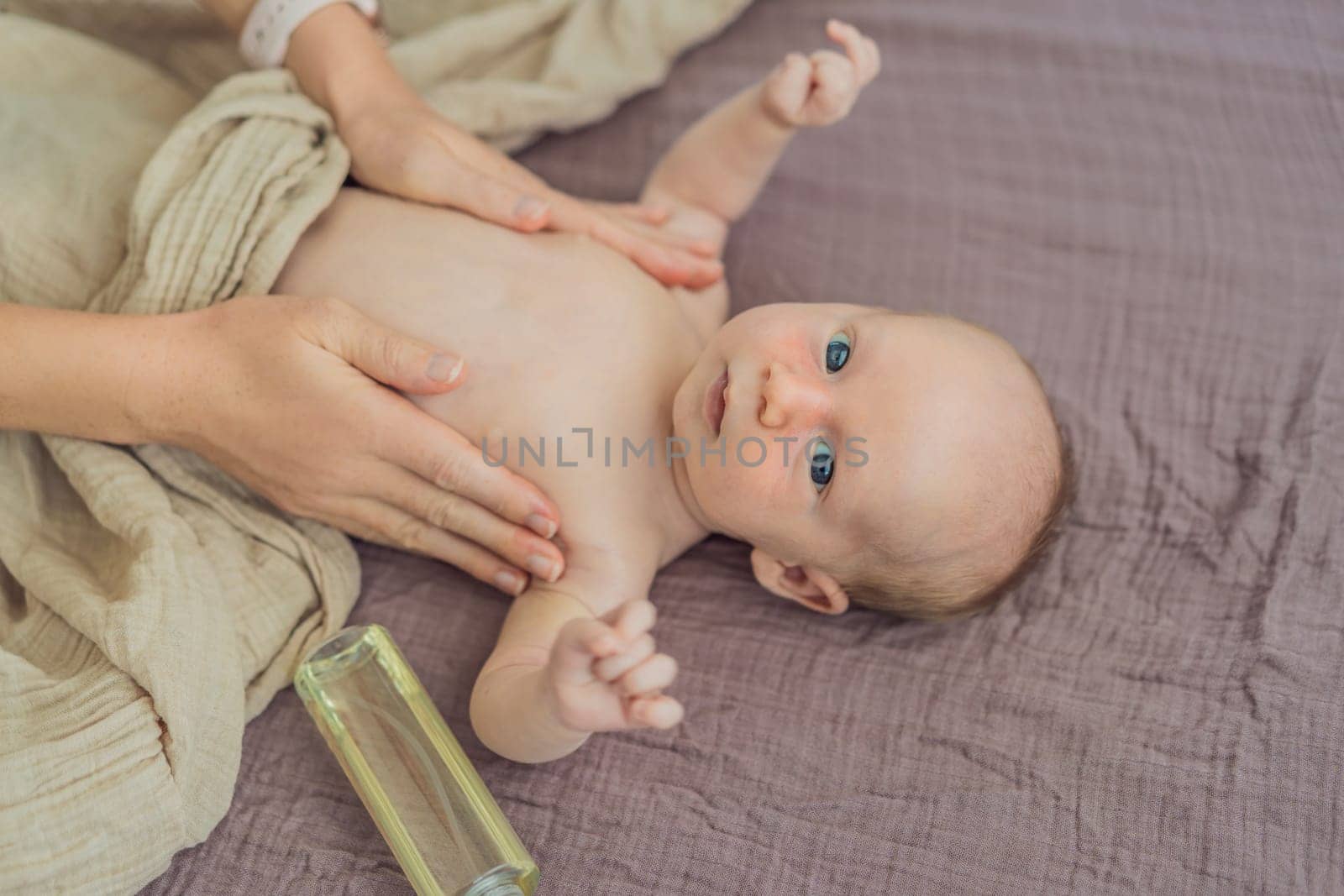 A mother gently massages her 1-month-old baby with baby oil after a bath. This tender moment highlights the bond between parent and child, promoting relaxation, baby care, and the importance of skin-to-skin contact.