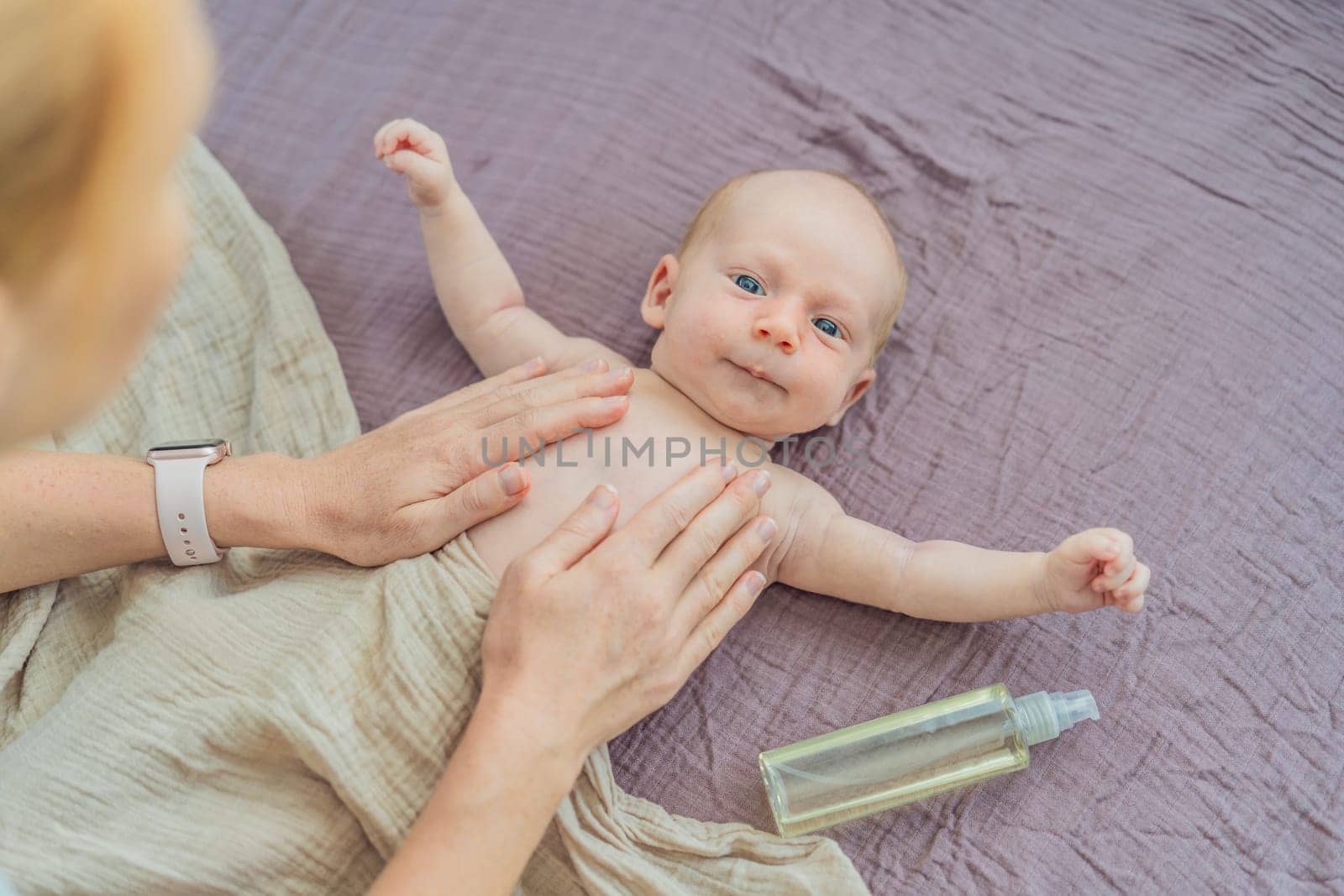 A mother gently massages her 1-month-old baby with baby oil after a bath. This tender moment highlights the bond between parent and child, promoting relaxation, baby care, and the importance of skin-to-skin contact.