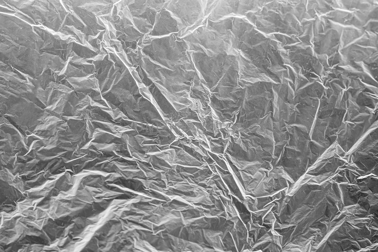 A textured light gray crumpled paper background with natural creases and folds. Ideal for design projects, digital graphics, or creative presentations requiring a vibrant.