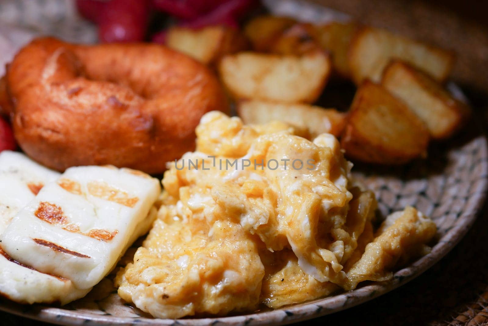 A delicious breakfast with scrambled eggs, cheese, and golden potatoes.