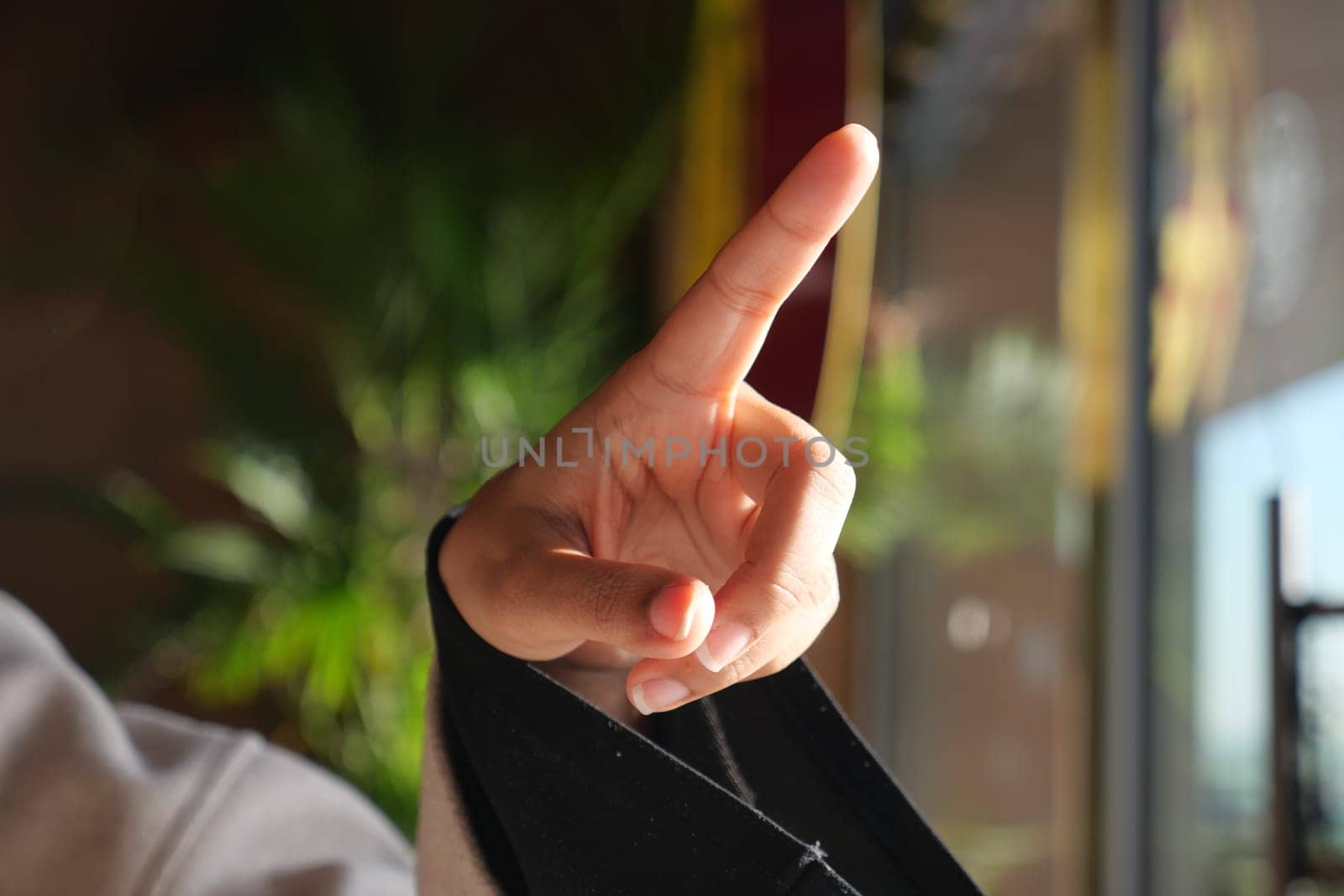 A hand is raised with one finger pointed, indicating a point of discussion.