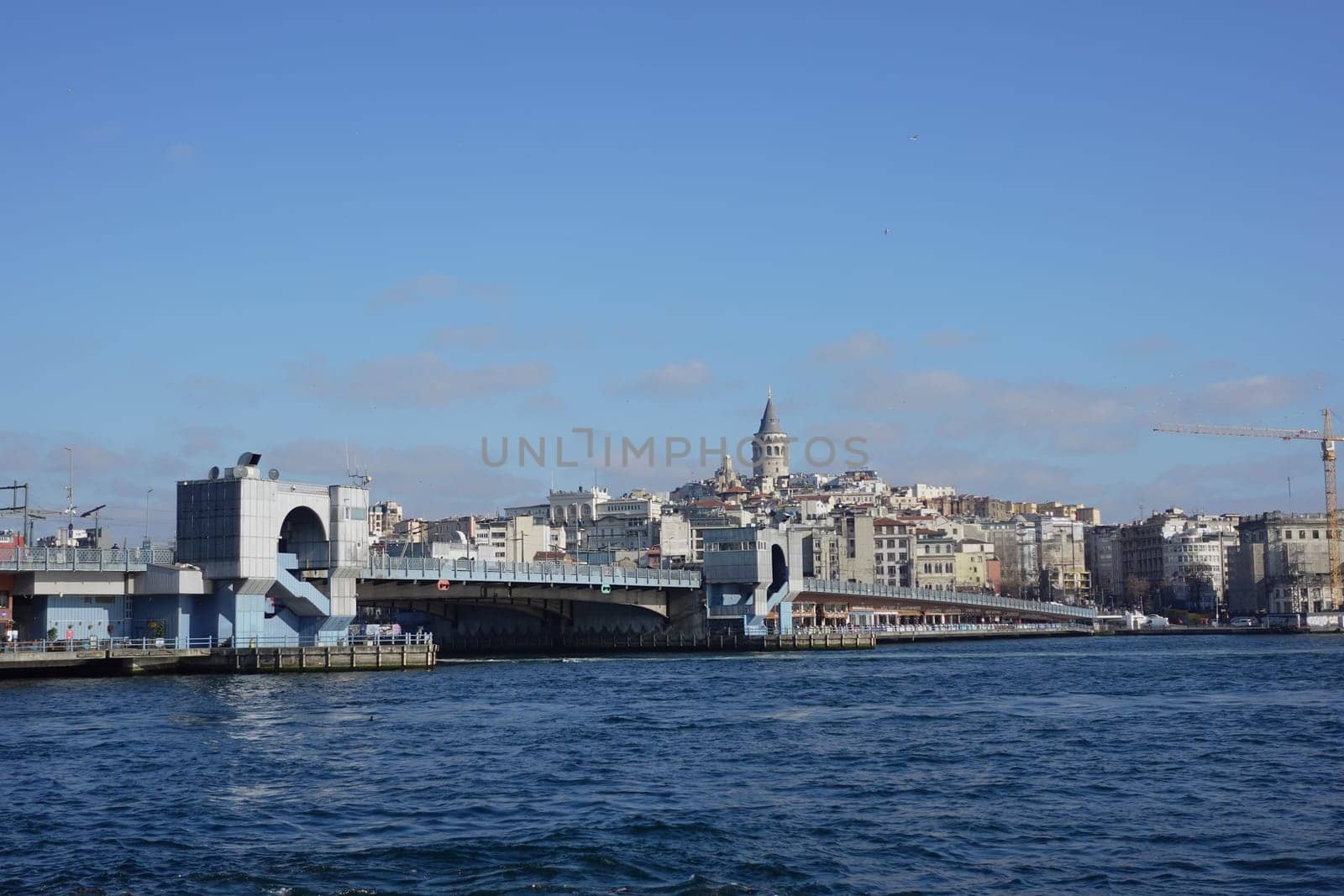 Galata Bridge spans the water, with city buildings and a tower in background.