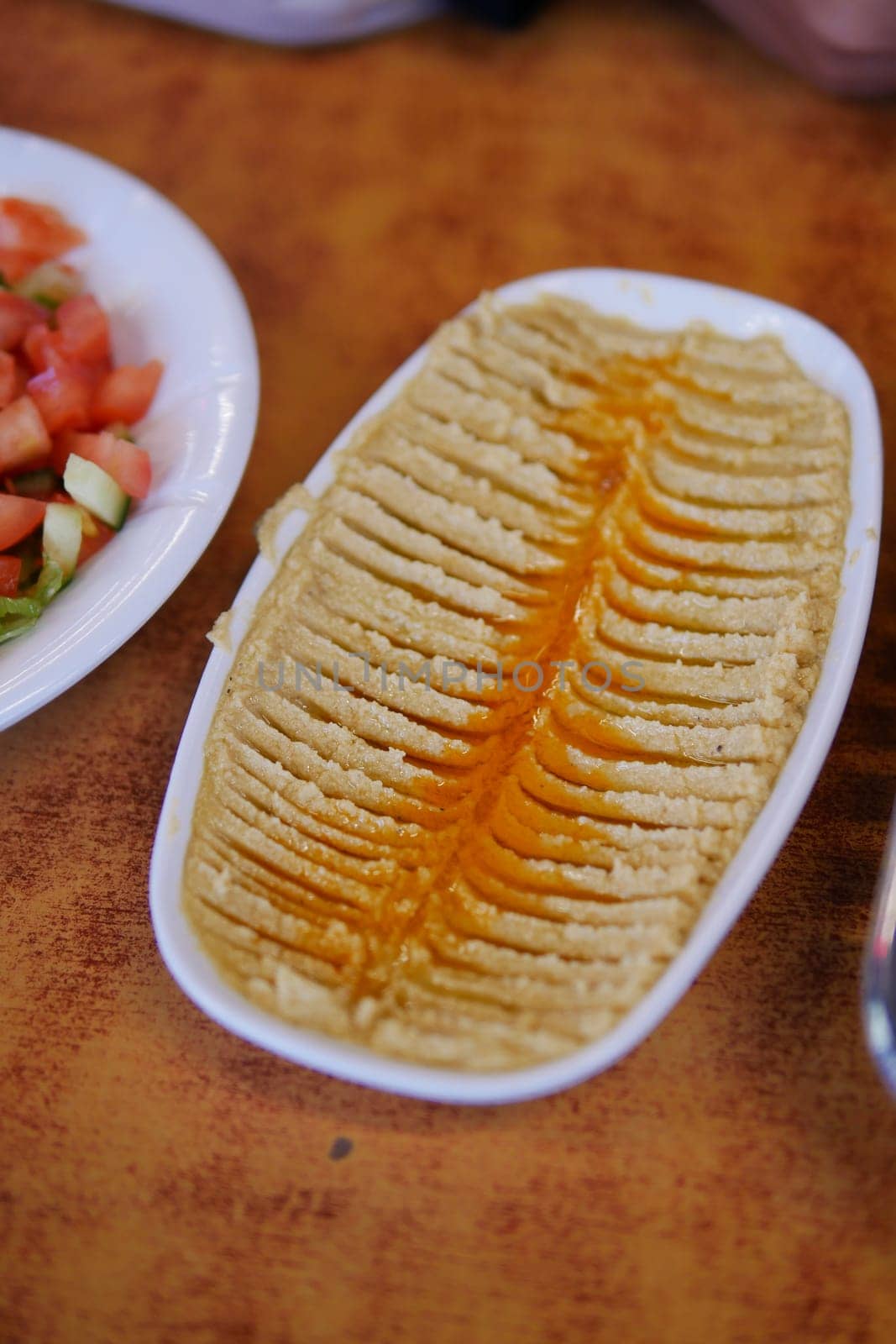 A creamy hummus plate garnished with a drizzle of oil and spices.