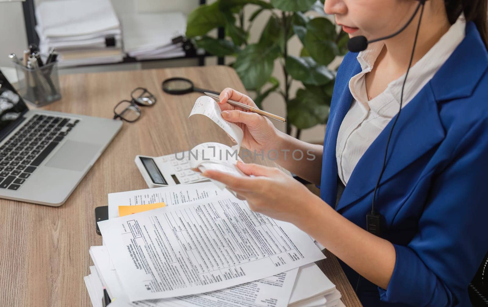 A dedicated professional woman is reviewing receipts and tax documents, emphasizing her role in tax management and organization within her office space.