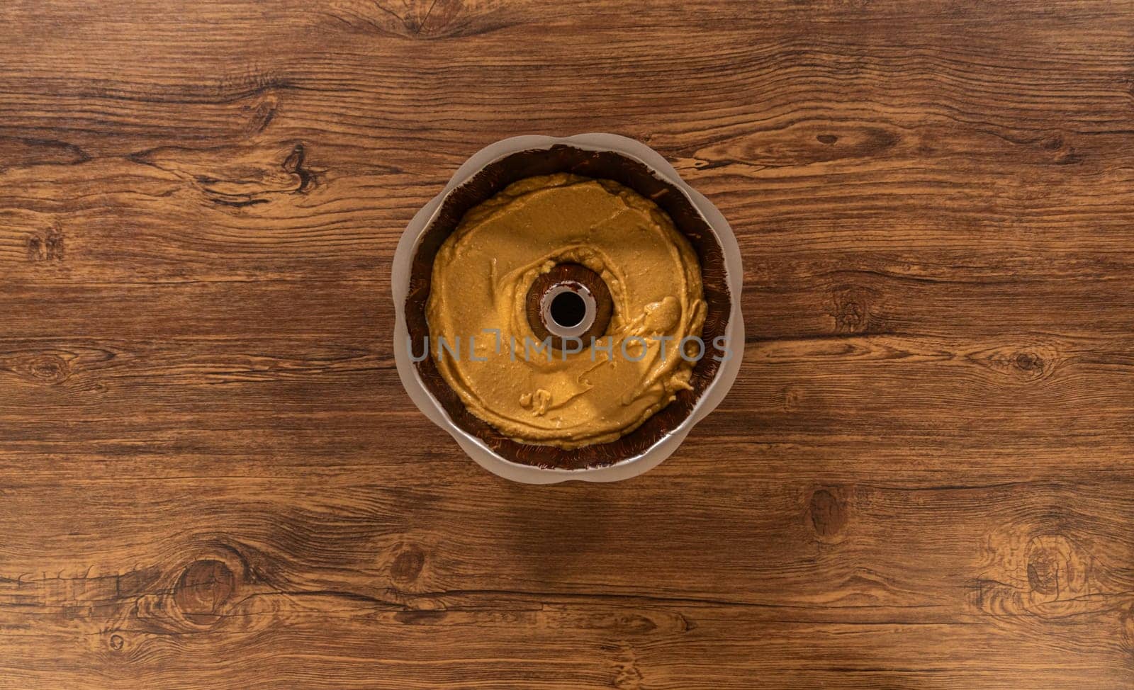 Flat lay. Pouring the gingerbread cake batter into the greased bundt cake pan, ready for a delightful caramel frosting.