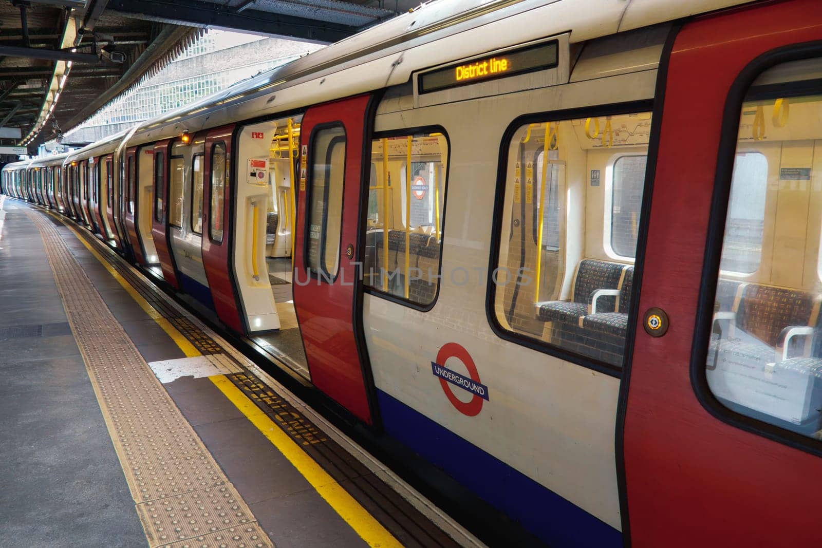 London, UK - September 28 2024: A district line underground train into view at London Edgware Road Tube Station. Empty seats are visible.
