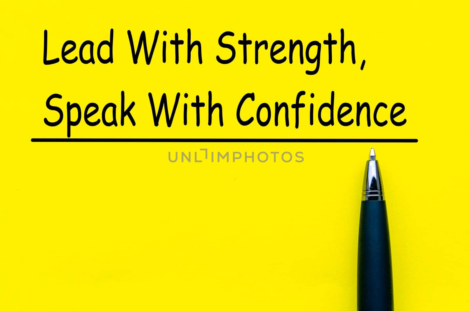 Lead with strength and speak with confidence text on yellow notepad.