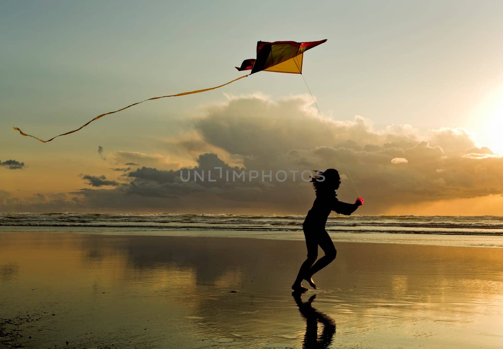 A girl flies a kite near sunset on the beach in Newport, Oregon.