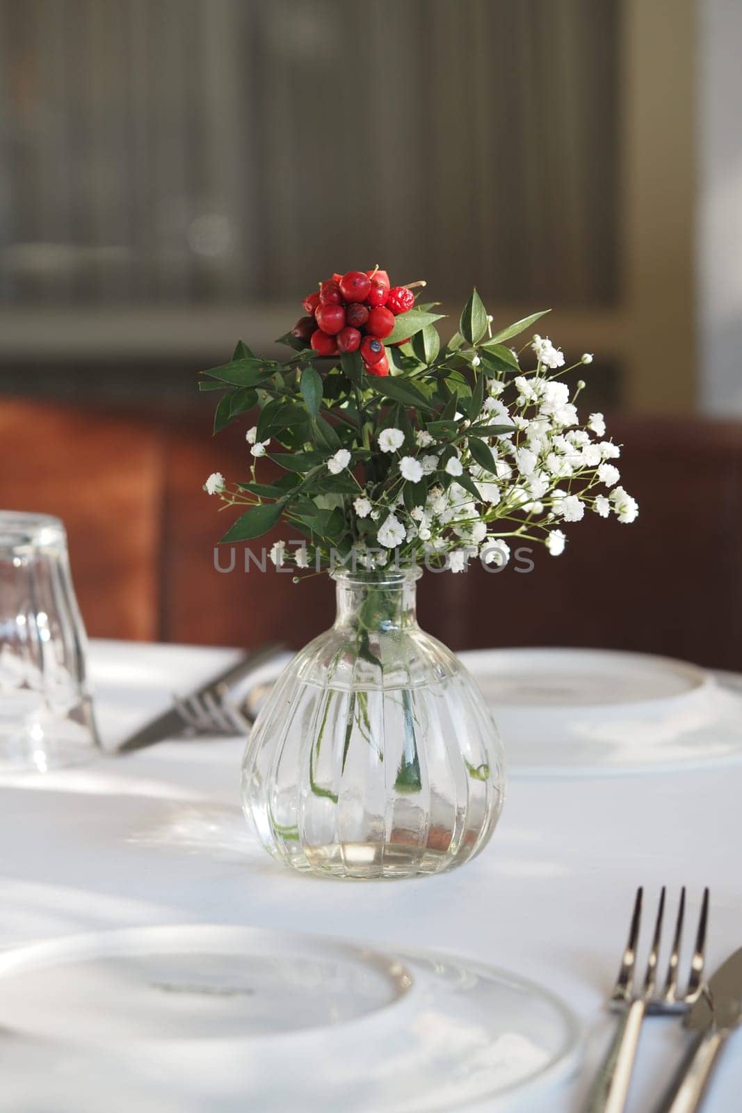 A charming flower arrangement decorates a dining table setting.