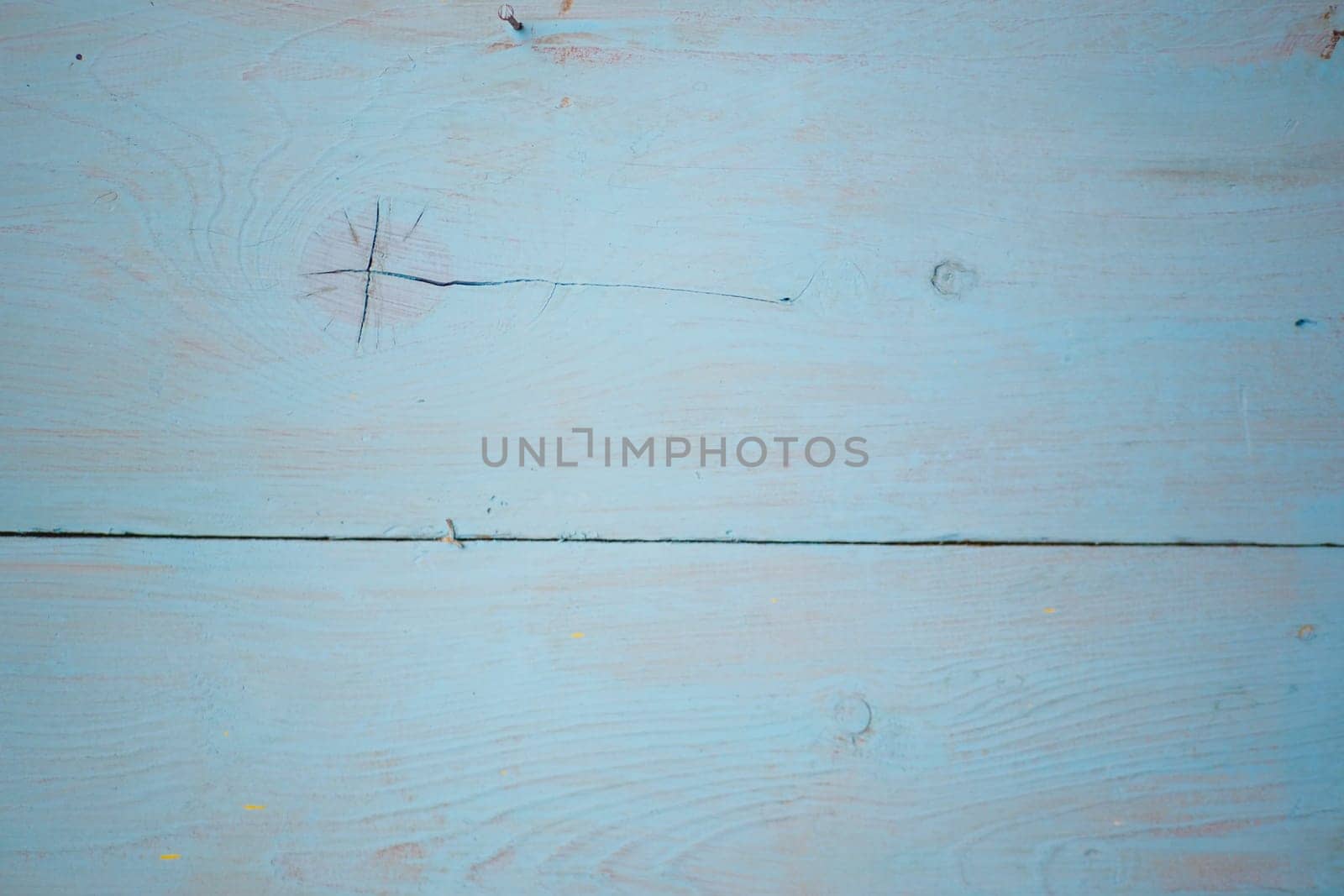 Close-up of a smooth light blue wood surface showcasing natural patterns.