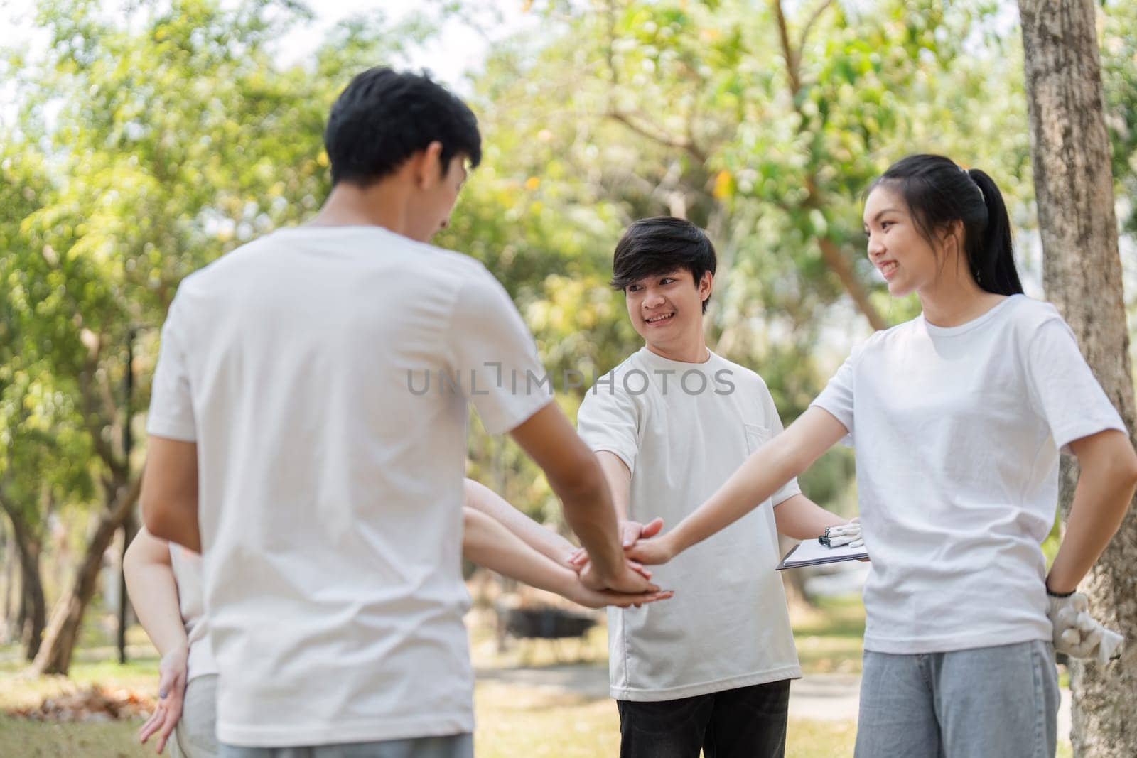 A group of engaged young volunteers collaborates in a park, preparing for their cleanup initiative while promoting teamwork and community spirit.