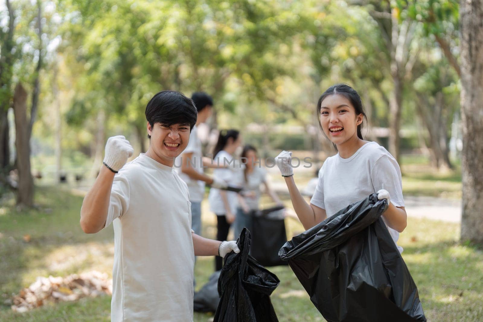 Two young volunteers celebrating their efforts with a fist pump, demonstrating enthusiasm for their community cleanup initiative.