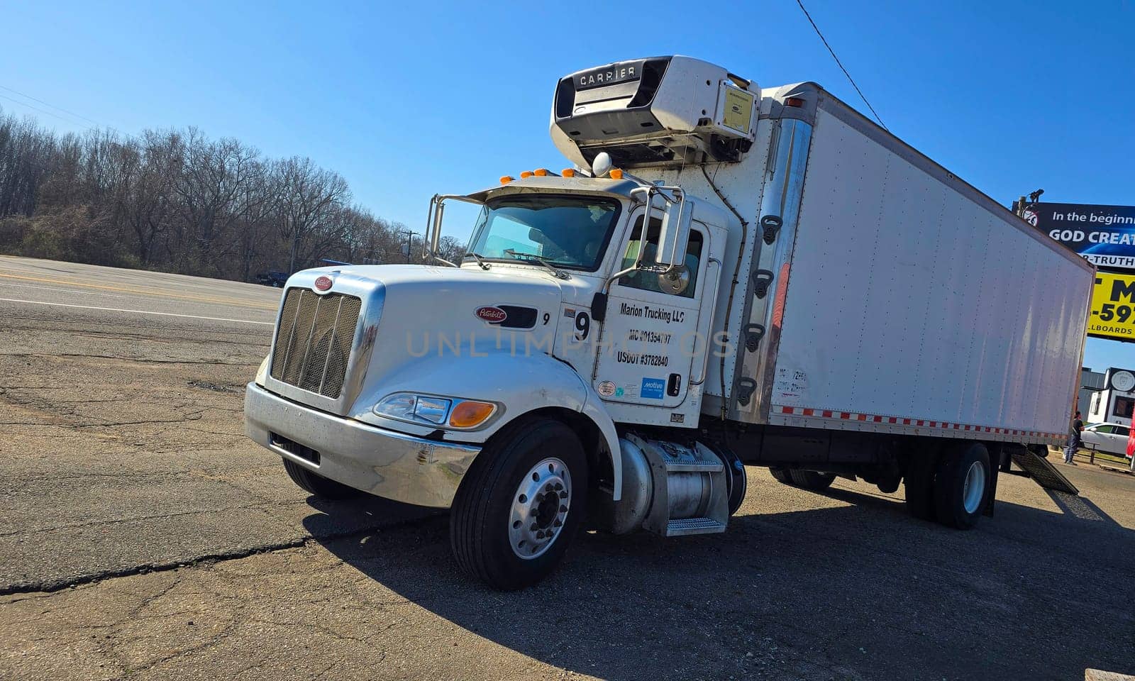 Freight liner Semi-Truck Driving on Open Highway in a Rural Area, CDL Truck America, semi truck and trailer travels along an open road under a blue sky in a rustic rural setting, showcasing commercial transportation, logistics efficiency, and professional trucking