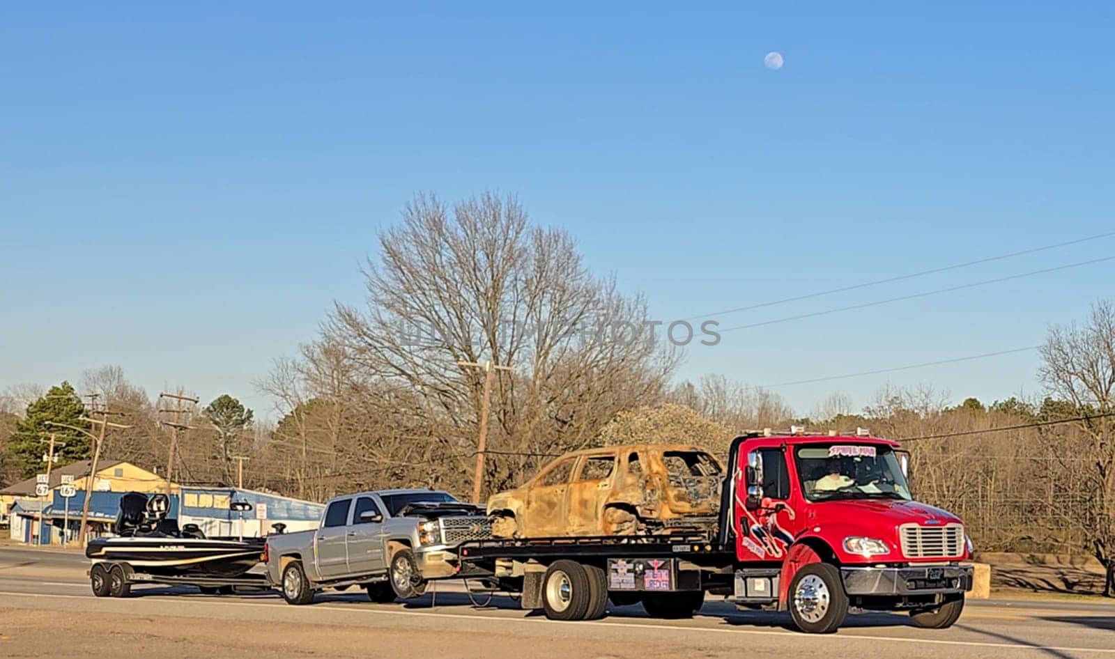 Freight liner Semi-Truck Driving on Open Highway in a Rural Area, CDL Truck America, semi truck and trailer travels along an open road under a blue sky in a rustic rural setting, showcasing commercial transportation, logistics efficiency, and professional trucking