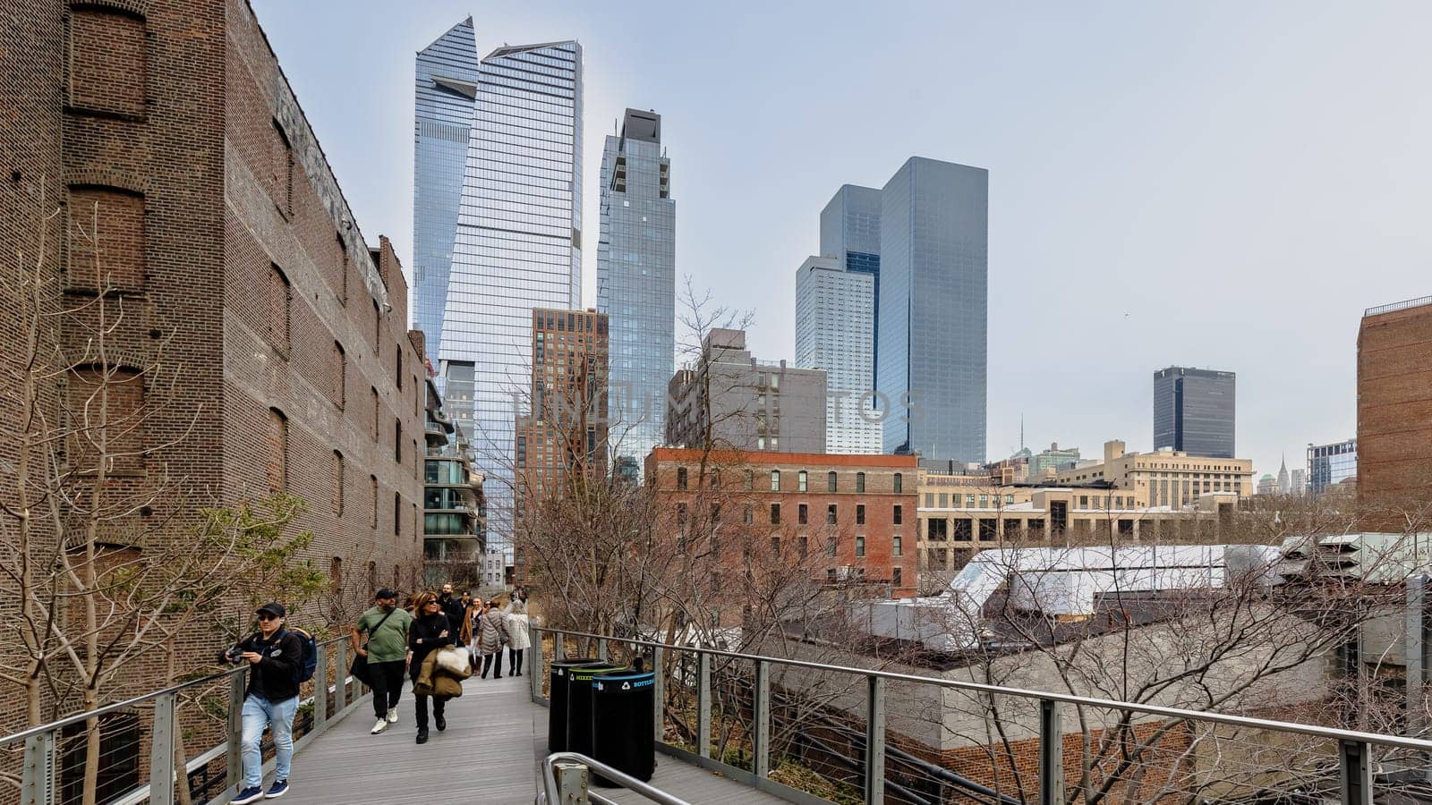 Manhattan, New York, USA - February 16, 2024: View of the Hight Line with its typical buildings seen from above as people visit on a gray winter day