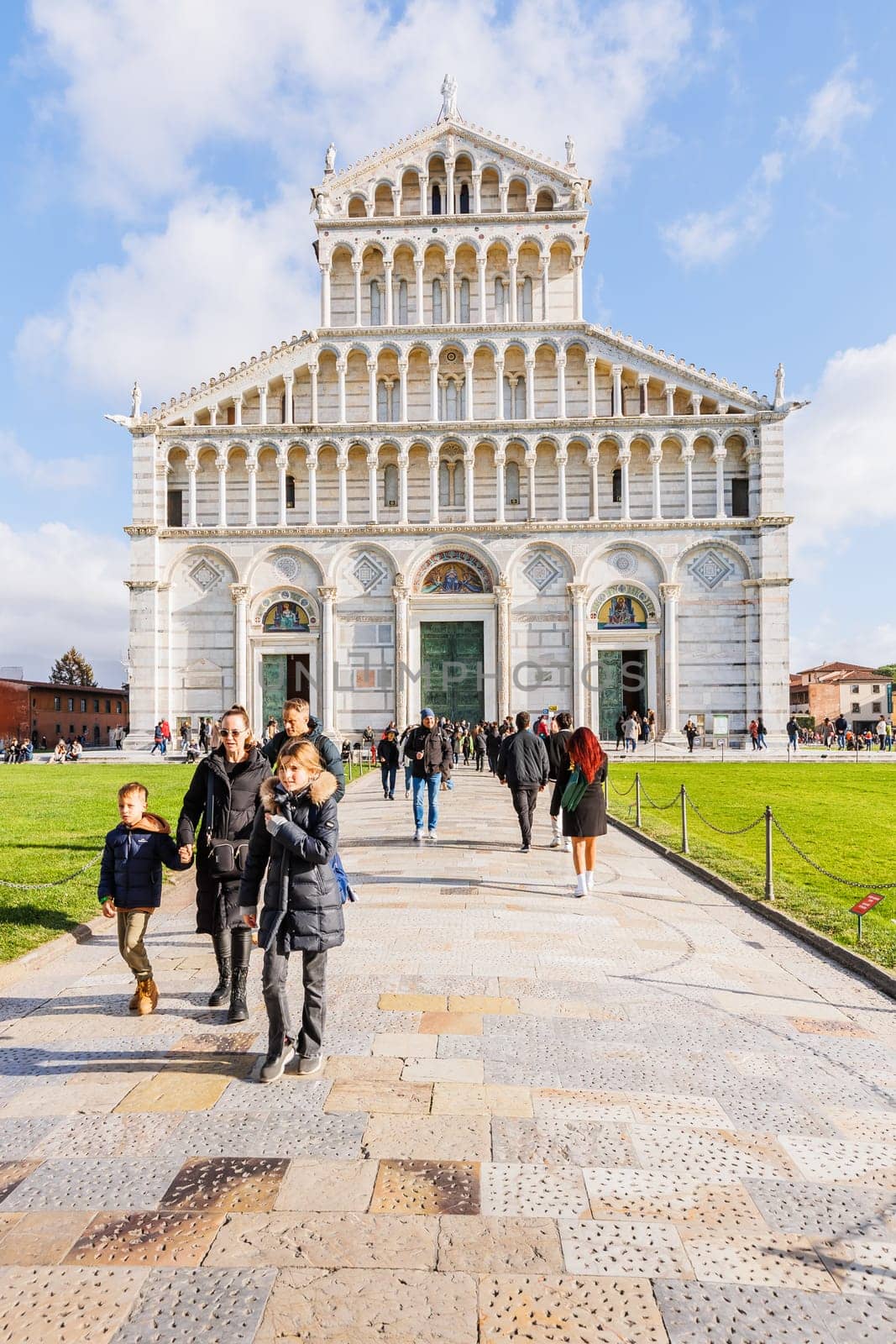 Pisa, Tuscany, Italy - January 04, 2024: Architectural detail of Pisa Cathedral "Catterdrale di Pisa" where tourists are walking on a beautiful winter day