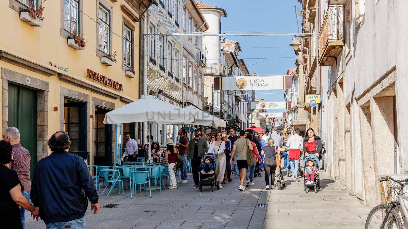 Braga, Portugal - May 26, 2024: Street atmosphere in the historic city center during the Braga Romana event with visitors walking around on a spring day