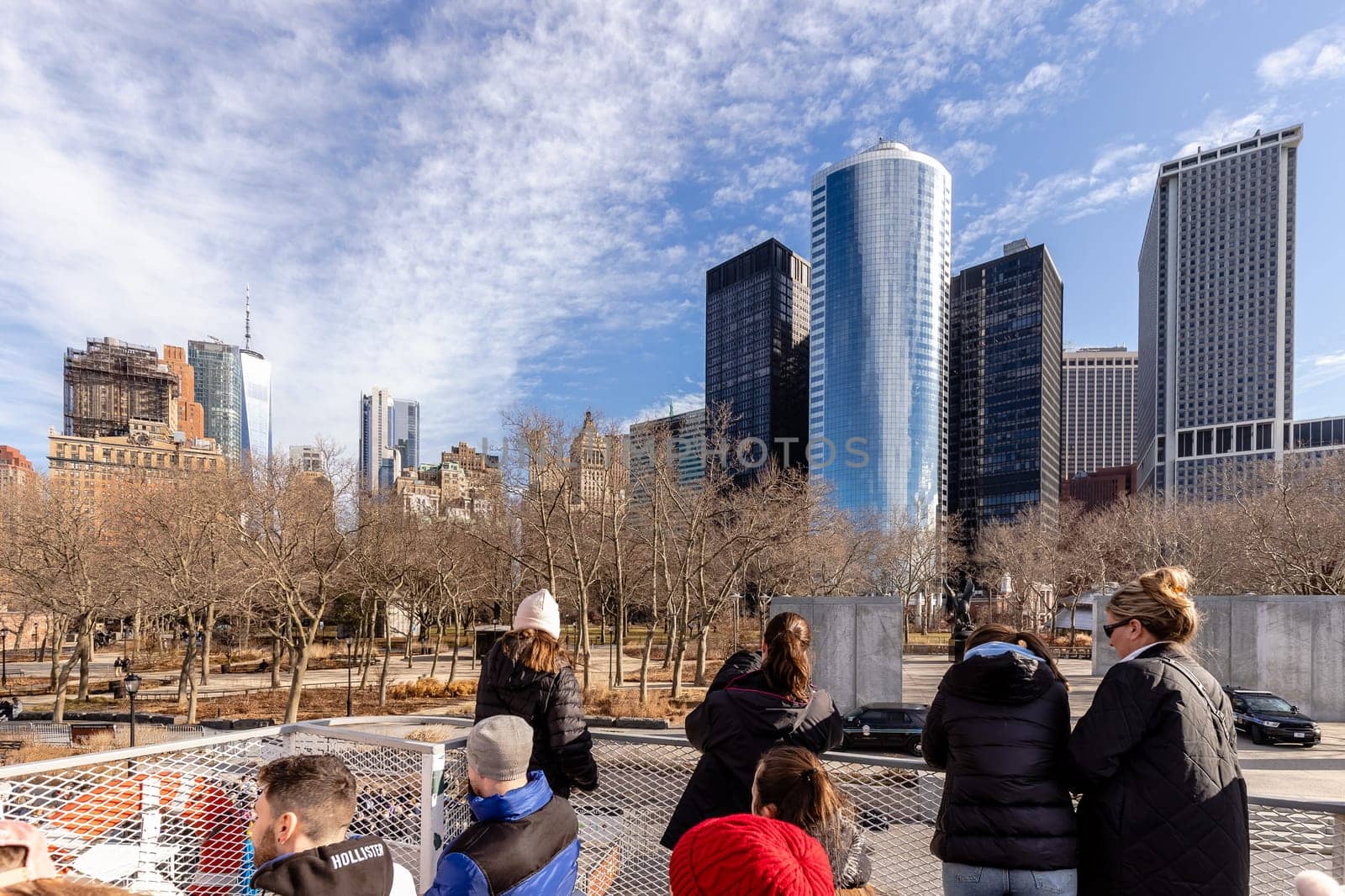 New York City, USA - February 13, 2023 - Tourists taking photos of Manhattan on a ferry from Manhattan to the Statue of Liberty on a winter day