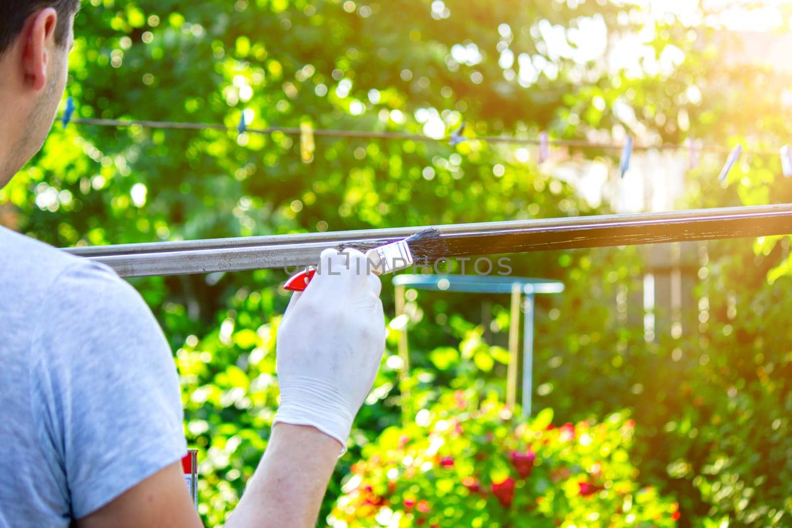 close up of painting metal with brush in garden