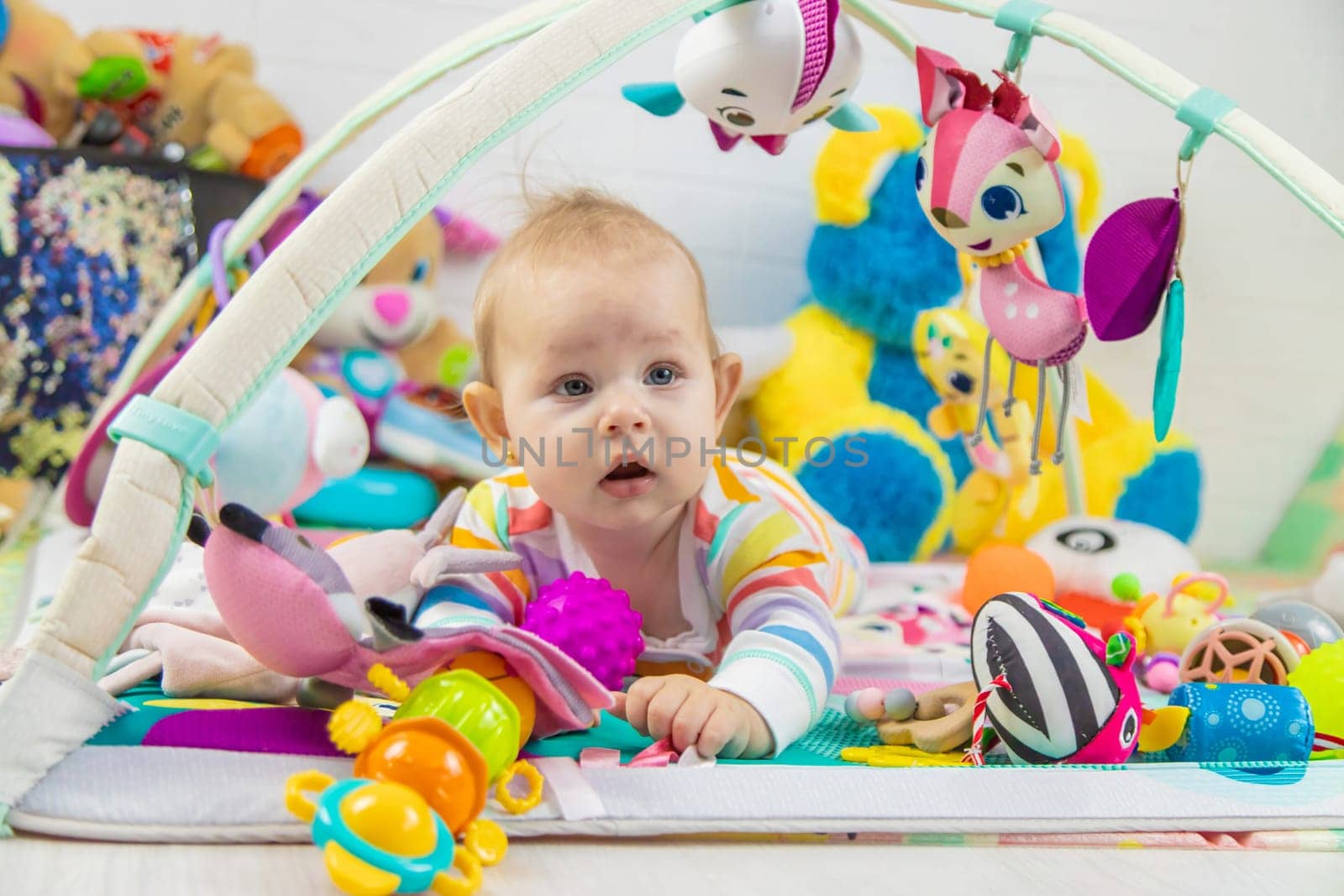 Baby playing on a toy mat. Child with an educational toy. Early development.