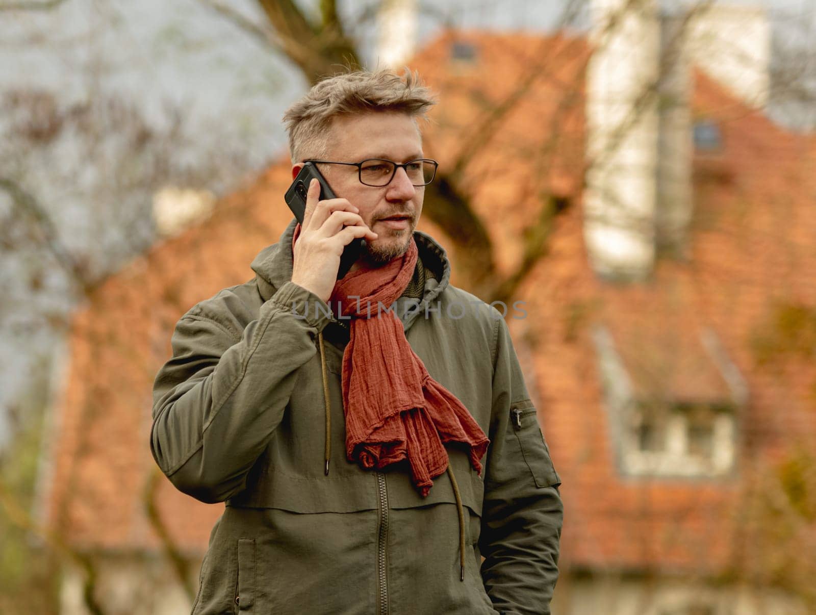 Young Attractive Man On A Street Has A Smartphone Call, Portrait In Glasses