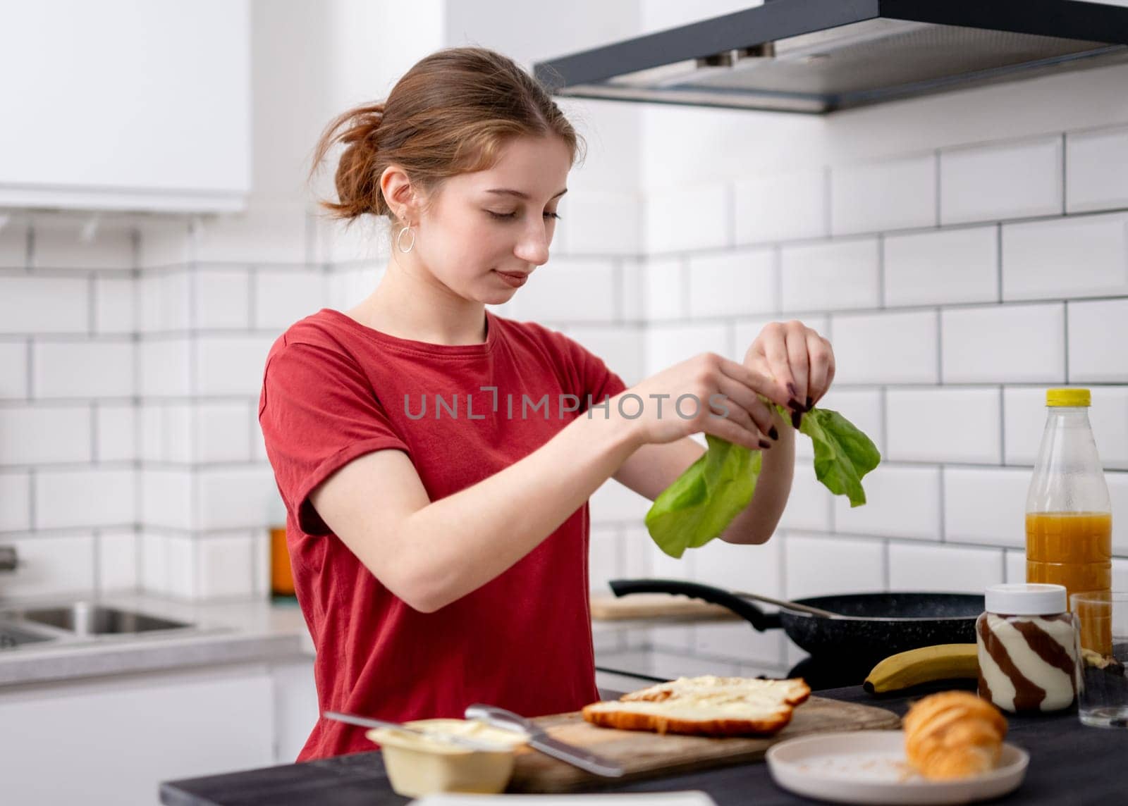 Sweet Girl Makes Stuffed Croissant For Breakfast In The Kitchen At Home