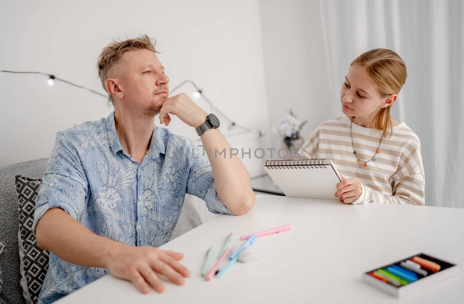 Little Girl Drawing A Portrait Of Dad, Happy Family At Home Having Fun