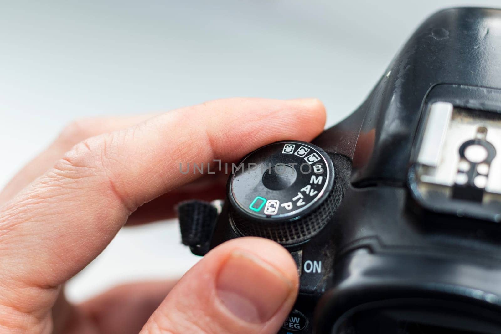 Man rotating mode dial on old camera