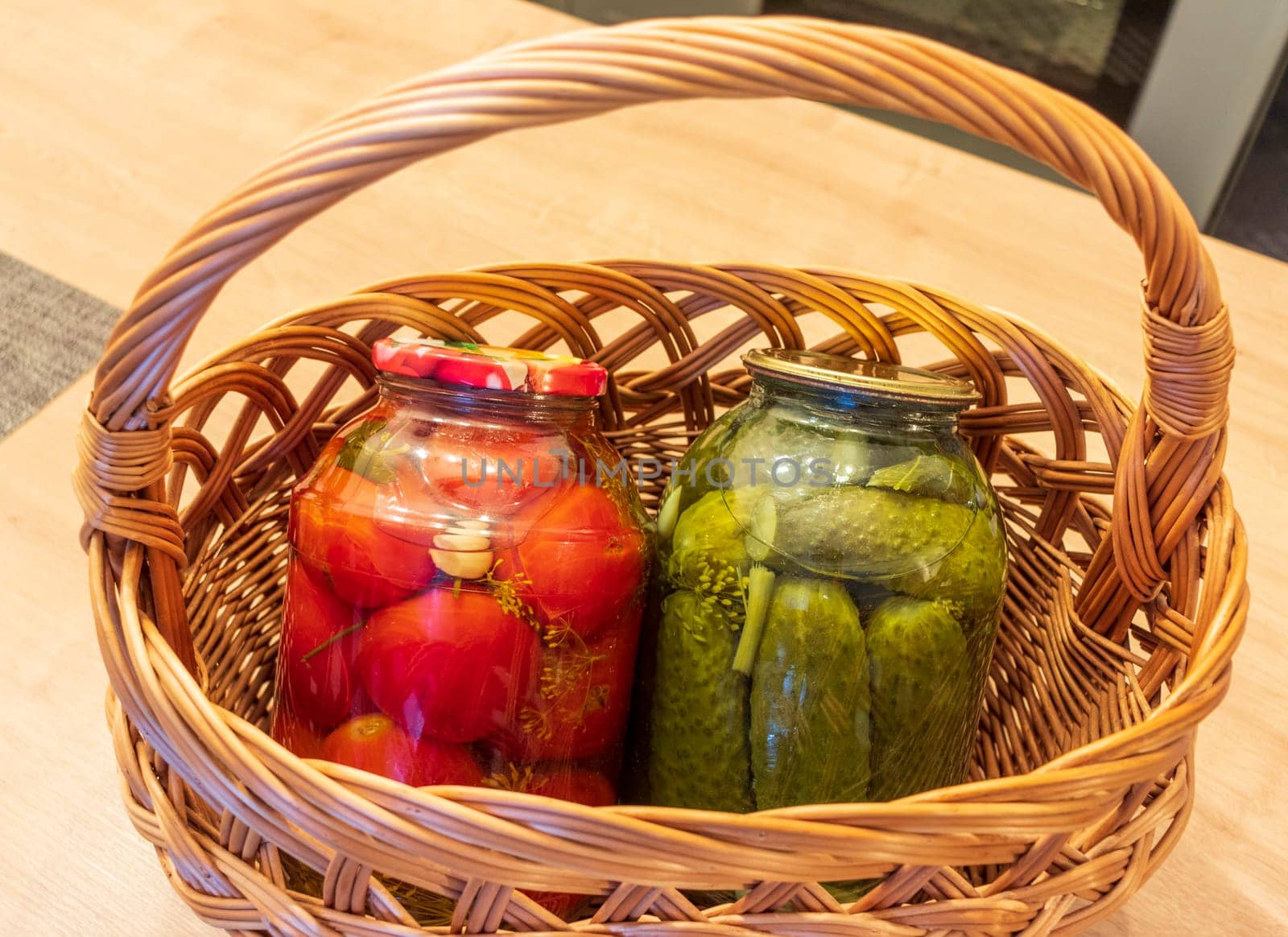 Jars with different types of pickles and preserves in a wicker basket