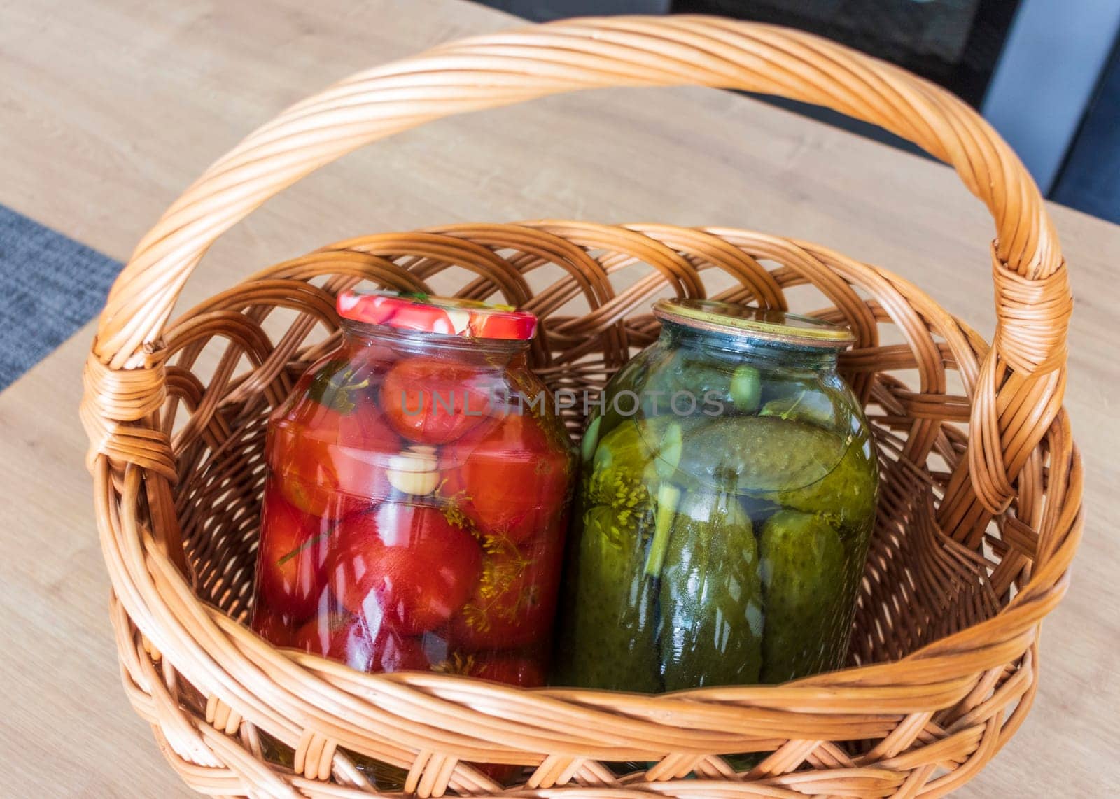 Jars with different types of pickles and preserves in a wicker basket