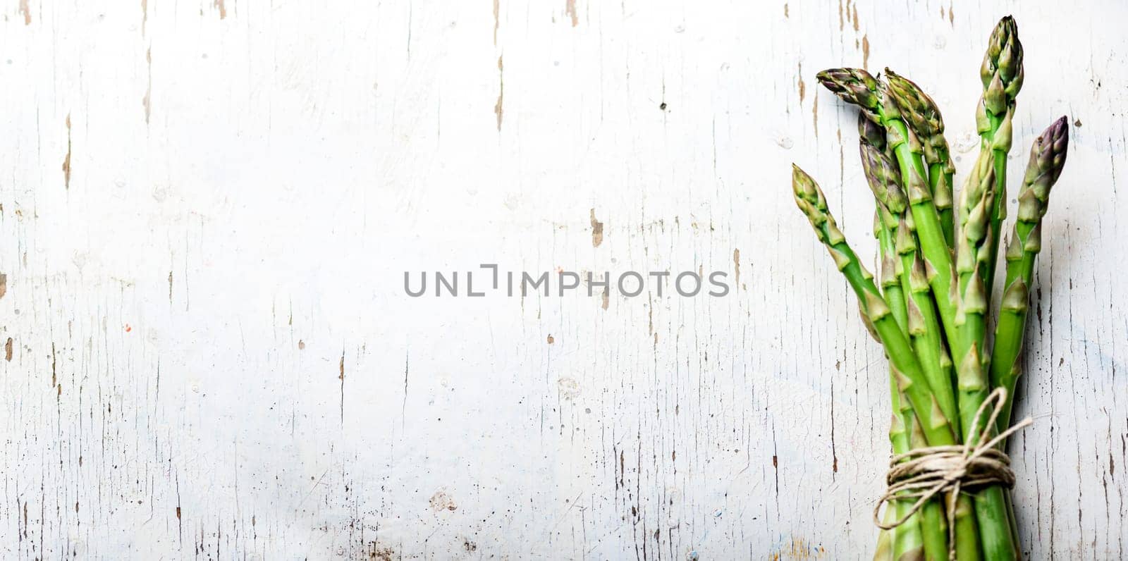 Top view of fresh green asparagus vegetable on vintage wood table. Healthy food background. Organic green vegan grocery from above. Restaurant menu design layout.