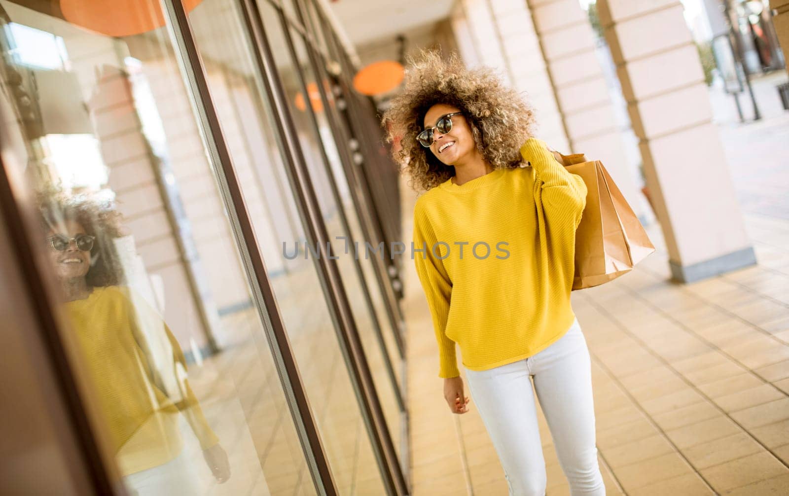 Pretty young black woman with curly hair in shopping