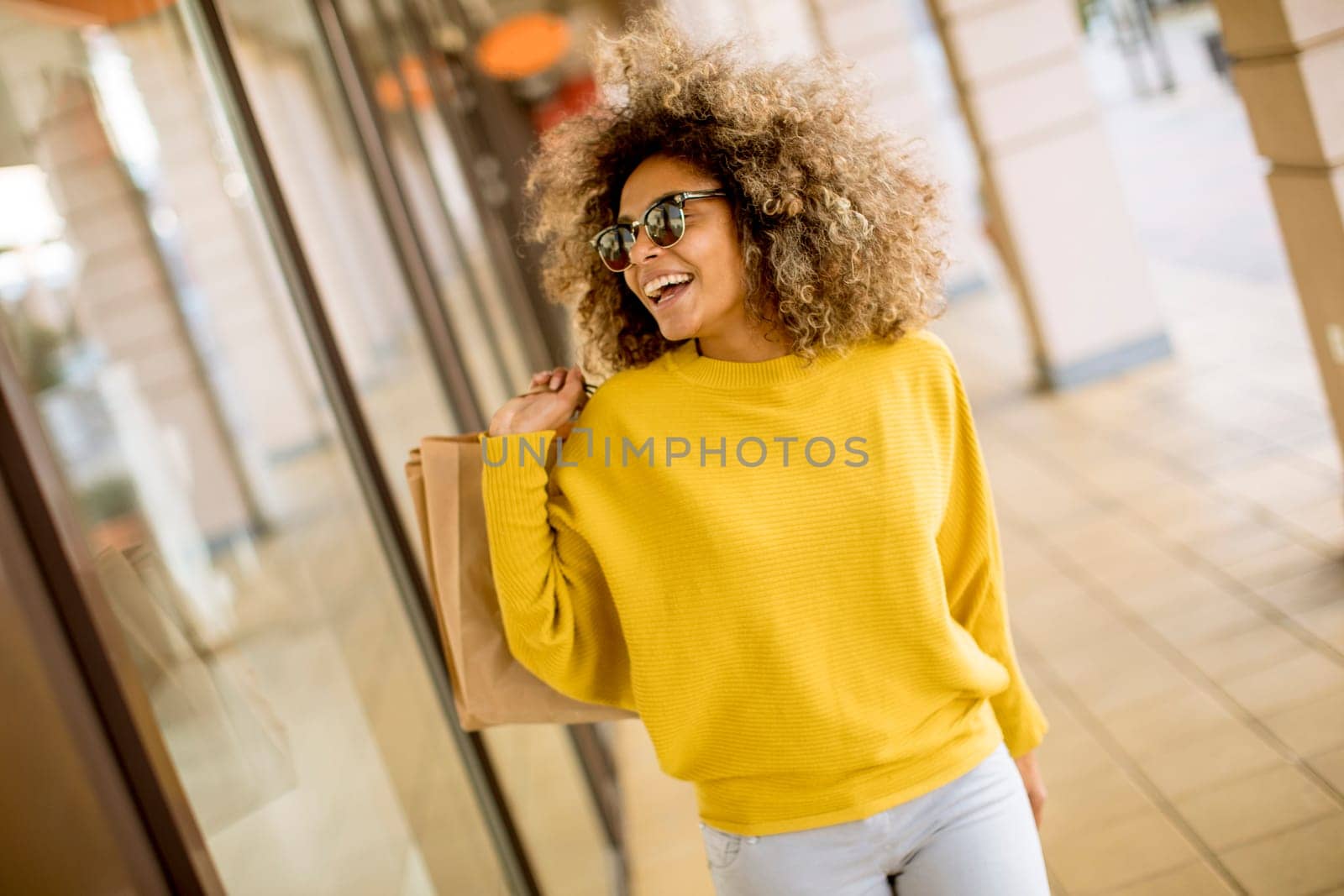 Pretty young black woman with curly hair in shopping