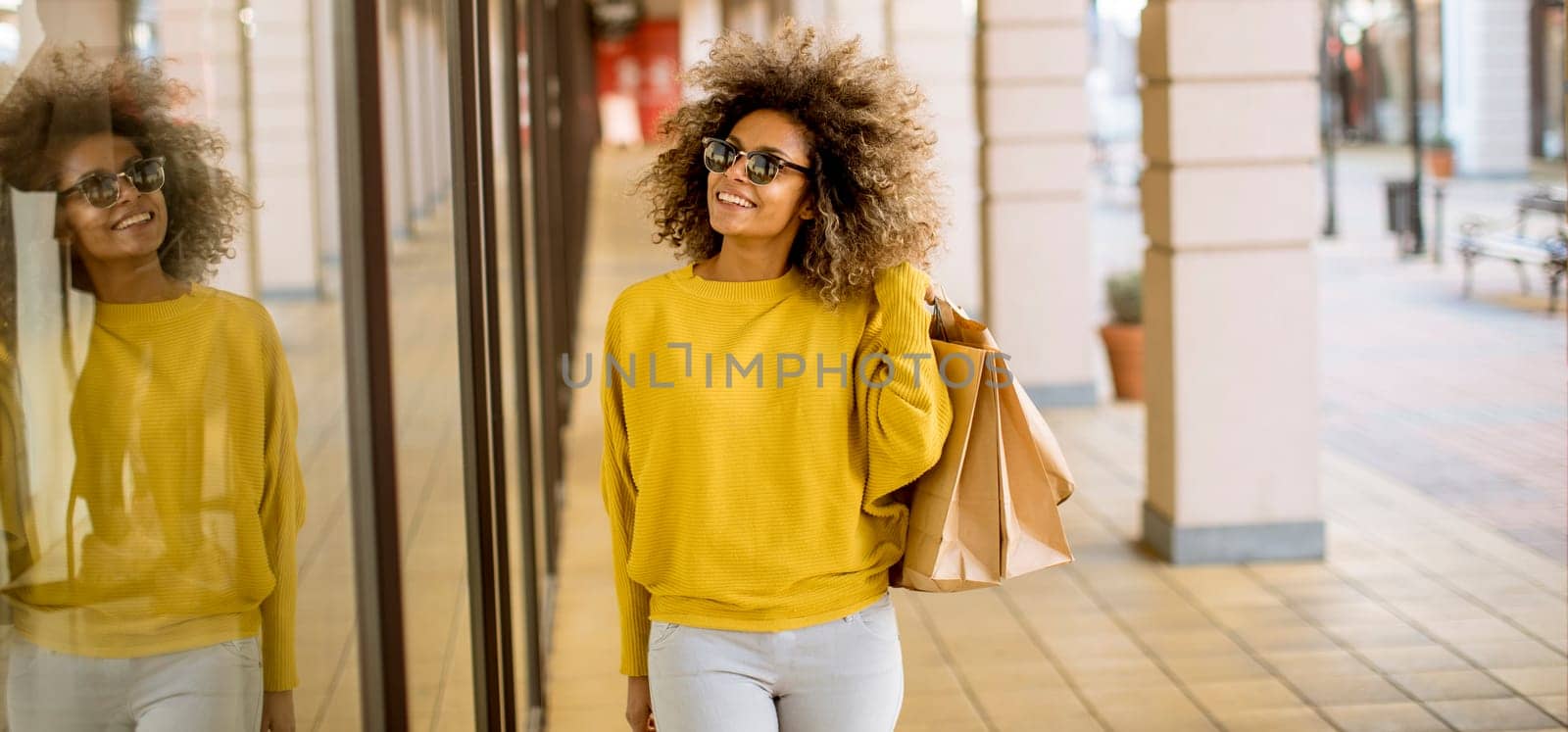Pretty young black woman with curly hair in shopping