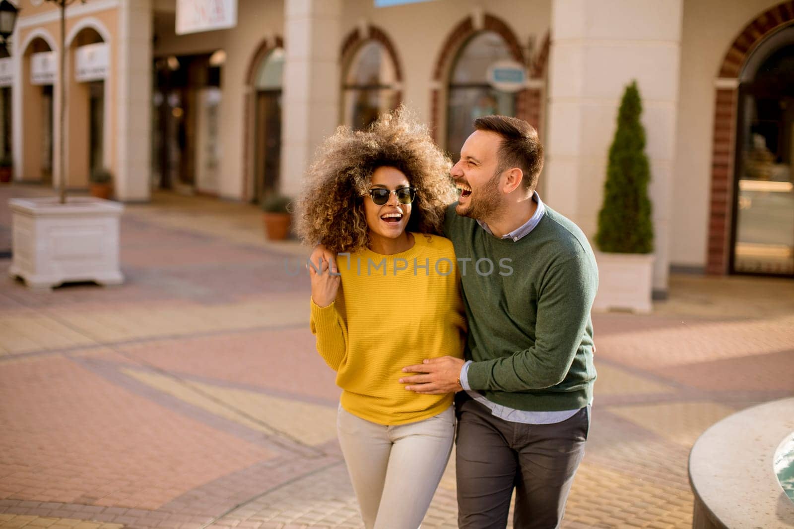 Lovely young multiethnic couple walking on the street