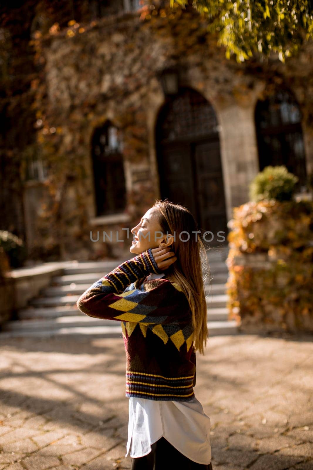 Pretty young woman walking in the autumn park on a sunny day