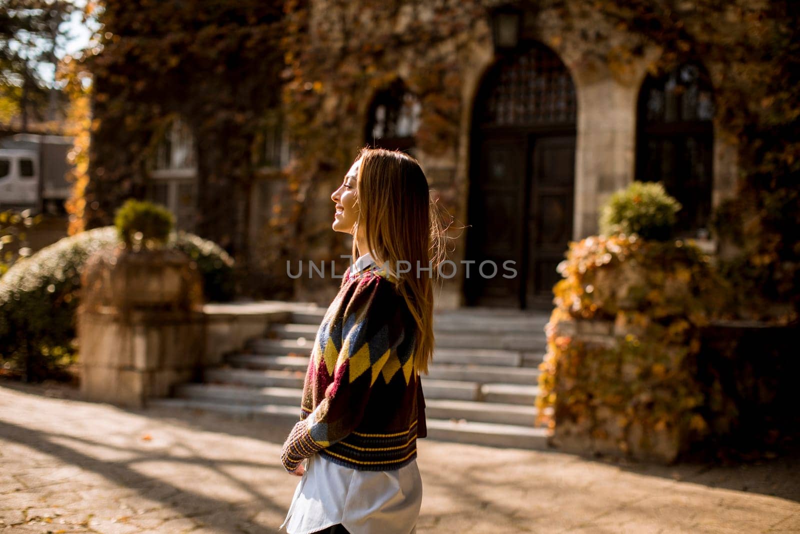 Pretty young woman walking in the autumn park on a sunny day