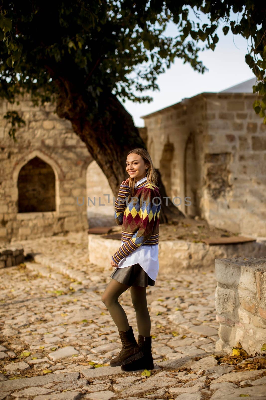 Pretty young woman walking in the autumn park on a sunny day