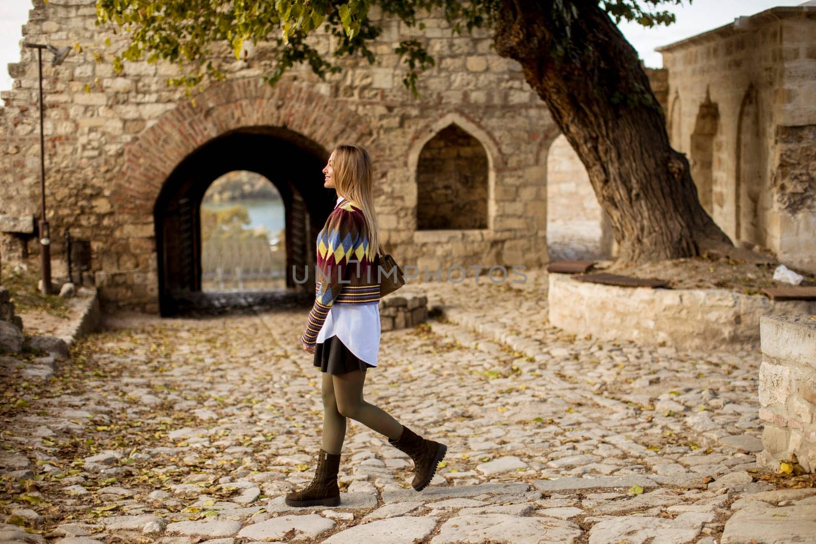 Pretty young woman walking in the autumn park on a sunny day