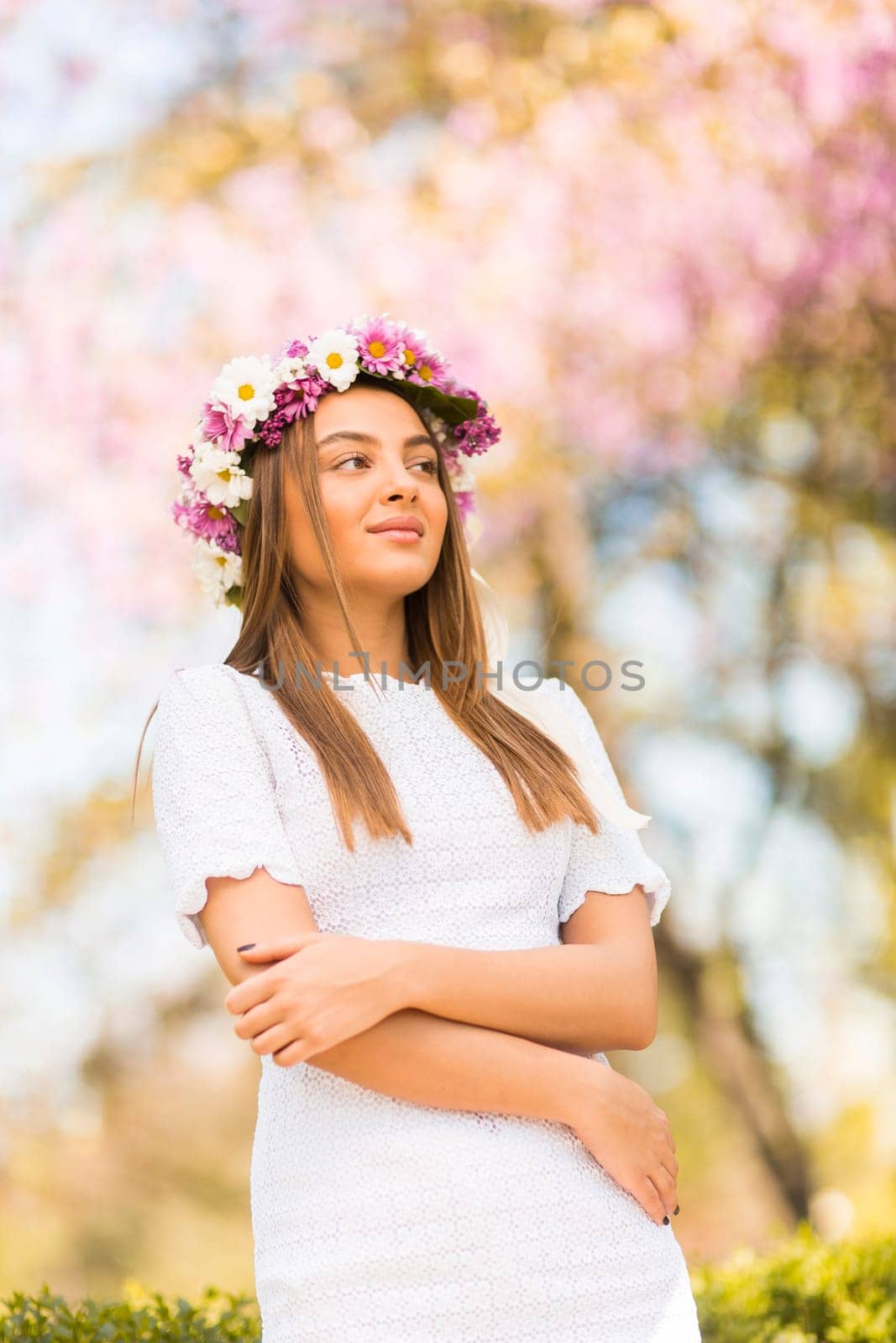 Pretty young woman with flowers in her hair on sunny spring day